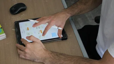 Las manos de Juani preparando una clase en una tableta